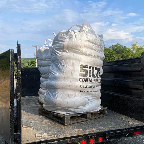 Two pallets of Silt Containment Silt Socks loaded in the back of a dump trailer.
